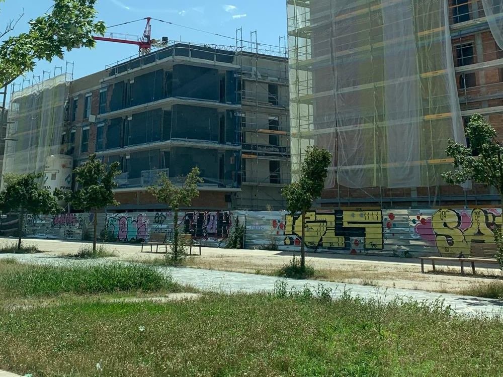 El mismo conjunto de Girona durante la obra, con el andamio montado y las redes de protección cubriendo las dos fachadas
