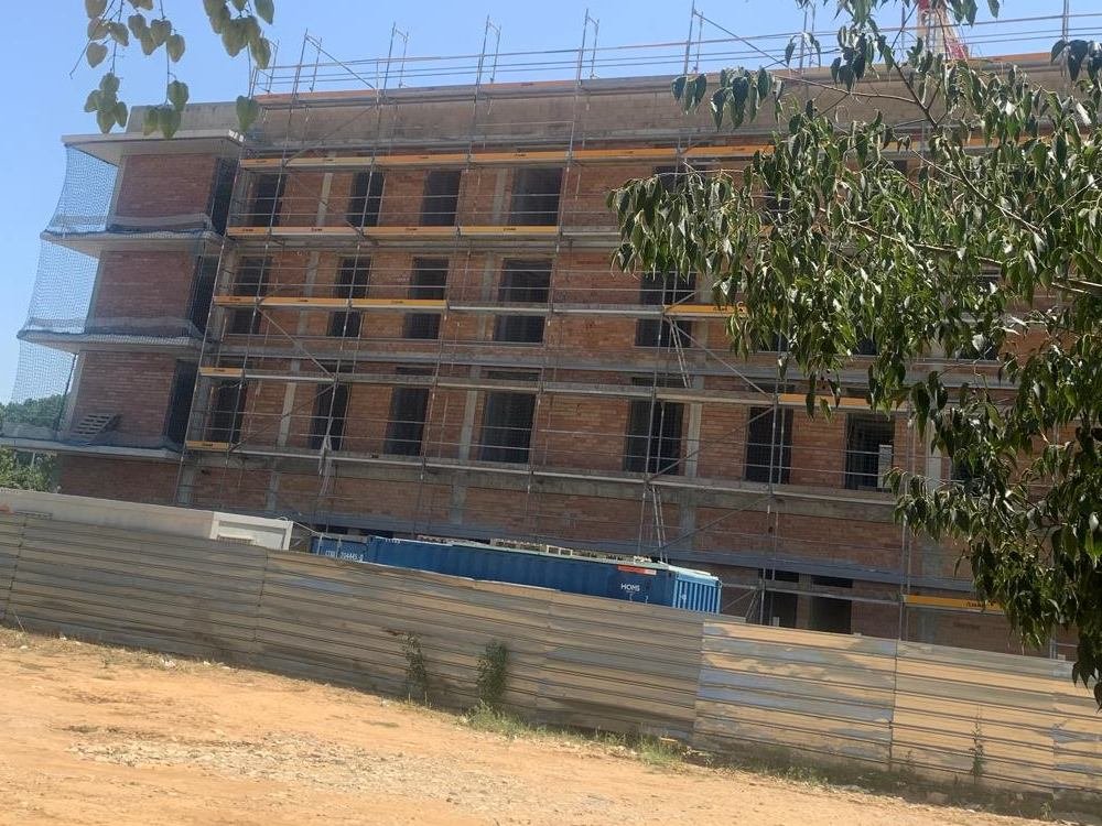 La estructura de fábrica de ladrillo del bloque de Girona antes de colocar el aislamiento, con el andamio montado en toda la fachada