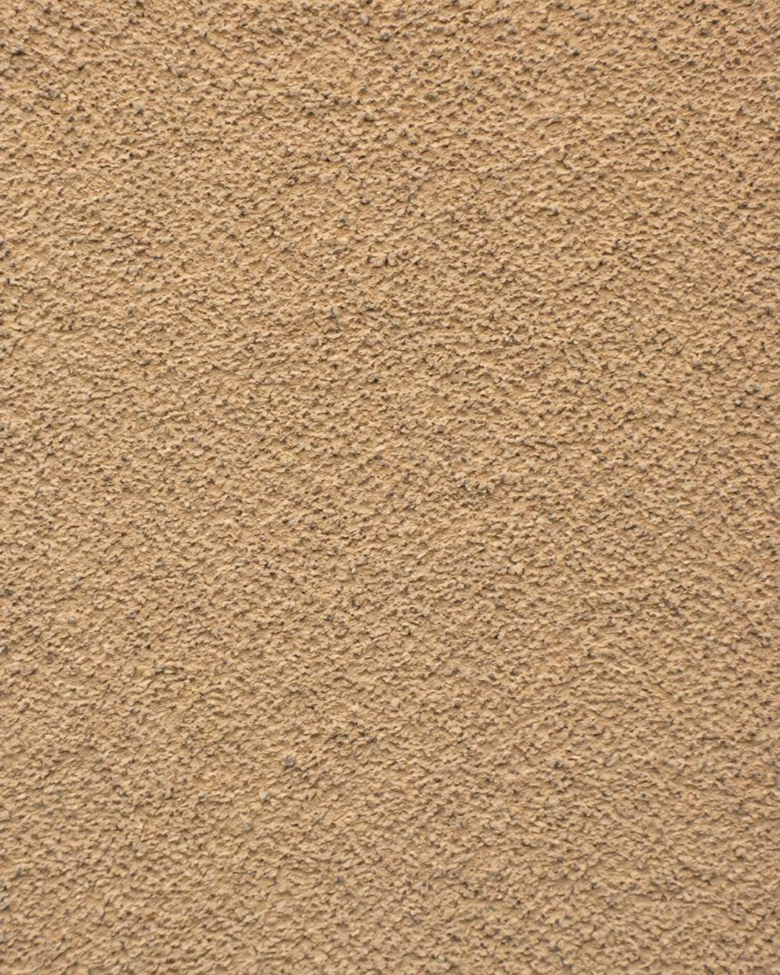 Textura de un revestimiento de fachada de mortero monocapa raspado en tono arena